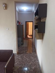 pasillo con sala de estar con sofá y pared en Bravo Apartment, Awka, en Akwa