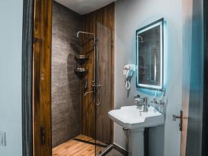 La salle de bains est pourvue d'un lavabo et d'une douche. dans l'établissement Art Plaza Hotel, à Tachkent