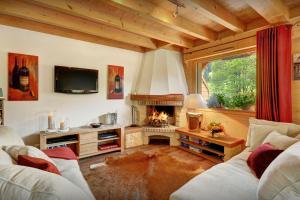 a living room with two couches and a fireplace at Chalet des Enfants La Clusaz - OVO Network in La Clusaz