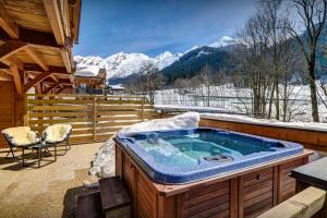 a jacuzzi tub on the deck of a cabin at Chalet des Enfants La Clusaz - OVO Network in La Clusaz