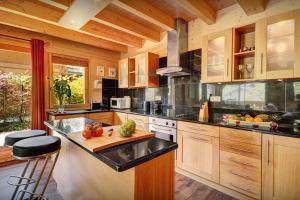 a kitchen with wooden cabinets and a black counter top at Chalet des Enfants La Clusaz - OVO Network in La Clusaz