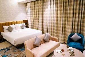 a hotel room with a bed and a couch and a chair at Enrise by Sayaji Nagpur in Nagpur