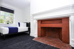 ボストンにあるStylish Hotel Room in Boston's Fenway - Unit #107のベッドルーム(レンガ造りの暖炉、ベッド付)