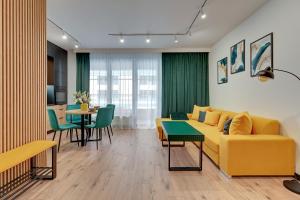 uma sala de estar com um sofá amarelo e uma mesa em Downtown Apartments DOKI Living - Foodhall & Parking em Gdansk