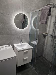 a bathroom with a sink and a shower at Apartamenty u Aleksandry in Ustronie Morskie