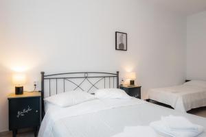 a bedroom with two beds and two lamps on tables at Pigi Rooms in Apollonia +13 photos