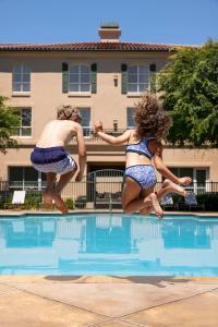 two women jumping into a swimming pool at Hyatt Regency Sonoma Wine Country in Santa Rosa