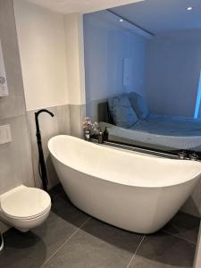 a bathroom with a white tub and a toilet at Stilvolle Stadtwohnung in Duisburg