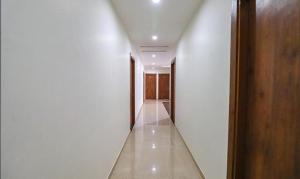 a hallway with white walls and a wooden door at FabExpress Pravi Inn in Lucknow