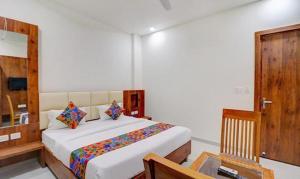 a bedroom with a bed and a table and a mirror at FabExpress Pravi Inn in Lucknow