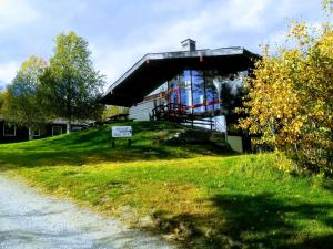 un edificio en una colina con un cartel en el césped en Dombåstun Motel, en Dombås