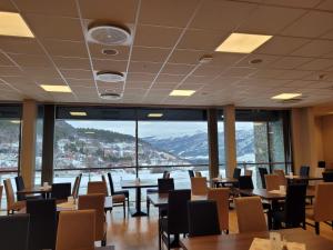 un restaurante con mesas y sillas y una gran ventana en Dombåstun, en Dombås