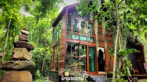 a tree house in the forest with a stack of rocks at MayamYay Privacy Homestay @Mea Nea Chiang Dao in Chiang Dao