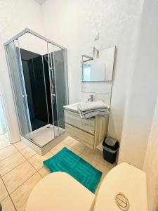 bagno con doccia, lavandino e specchio di Le Mirabelle a Saintes