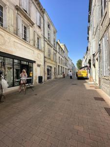 Una donna è in piedi in una strada di città di Le Mirabelle a Saintes