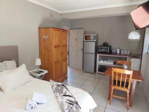 a room with a bed and a table and a kitchen at UNIQUE BnB in Vryheid