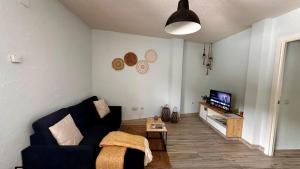 uma sala de estar com um sofá e uma televisão em Gredos Starlight House - AURIGA em Mijares