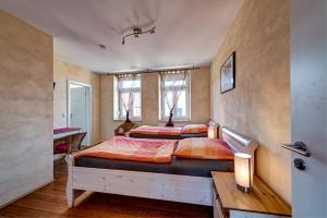 a bedroom with two beds and a desk at Jakobshof in Freckenfeld