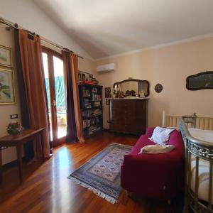 ein Wohnzimmer mit einem roten Sofa und Holzboden in der Unterkunft Amunì da Vita e Pietro in Carini