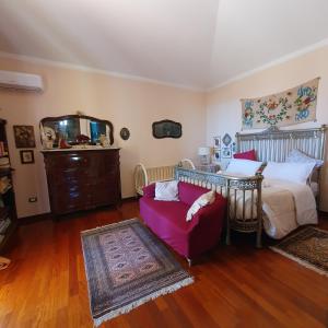 ein Schlafzimmer mit einem Bett, einem Sofa und einem Spiegel in der Unterkunft Amunì da Vita e Pietro in Carini