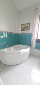eine weiße Badewanne im Bad mit blauen Fliesen in der Unterkunft Amunì da Vita e Pietro in Carini