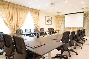 una sala de conferencias con una mesa larga y sillas en 10 2ND AVENUE HOUGHTON ESTATE BOUTIQUE HOTEL en Johannesburgo