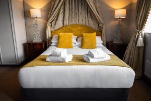a bedroom with a large bed with towels on it at Pennine Manor Hotel in Huddersfield