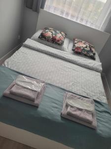 Duas camas individuais com toalhas e almofadas. em Apartament Słowińców 52 em Wejherowo
