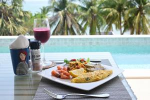 a plate of food on a table with a glass of wine at Dune Hua Hin Hotel in Hua Hin