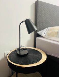 a black lamp on a table next to a bed at Ubytování Starobělská u Ostravar Arény in Nová Ves +3 photos
