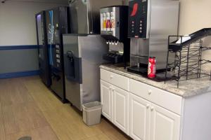 a kitchen with a stainless steel refrigerator and a counter at Econo Lodge in Waite Park
