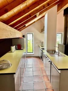 eine große Küche mit einer Spüle und einer Theke in der Unterkunft Grosszügige Dachwohnung in Tessiner Altbau in Monte Ceneri