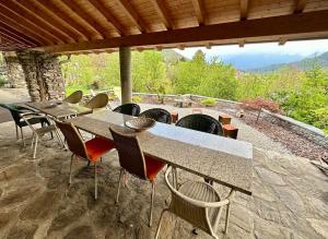 eine Terrasse mit Tischen und Stühlen und einem Kamin in der Unterkunft Grosszügige Dachwohnung in Tessiner Altbau in Monte Ceneri