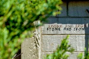 un cartello sul lato di un muro di mattoni di 石と鉄-House of STONE and IRON a Otaru