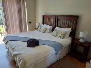 a bedroom with a large bed with a wooden headboard at UNIQUE BnB in Vryheid