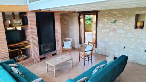 ein Wohnzimmer mit blauen Sofas und einem TV in der Unterkunft Domaine Jardin d'En Naoua in Maubec