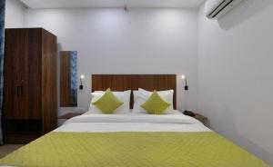 um quarto com uma cama grande com lençóis e almofadas verdes em Hotel The Emporio A Corporate Suites em Ghaziabad