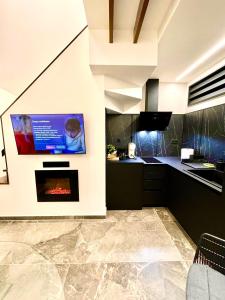 a kitchen with a tv on a wall with a fireplace at Modern Home Loft in Alexandroupoli
