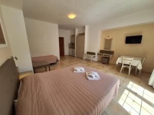 a hotel room with a bed and a table at Perla Beach in Agia Marina Nea Kydonias