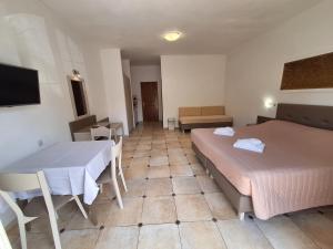 a hotel room with two beds and a table at Perla Beach in Agia Marina Nea Kydonias