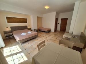 a bedroom with a bed and a table and chairs at Perla Beach in Agia Marina Nea Kydonias