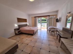 a hotel room with a bed and a table and chairs at Perla Beach in Agia Marina Nea Kydonias