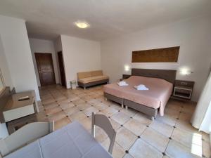 a hotel room with a bed and a couch at Perla Beach in Agia Marina Nea Kydonias