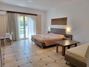 a hotel room with a bed and a table at Perla Beach in Agia Marina Nea Kydonias
