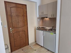 a kitchen with a wooden door and a sink at Perla Beach in Agia Marina Nea Kydonias