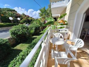 a balcony with a table and chairs on a building at Perla Beach in Agia Marina Nea Kydonias