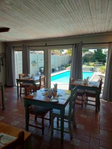 a dining room with tables and chairs and a pool at UNIQUE BnB in Vryheid