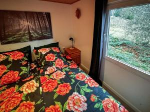 a bedroom with a bed with a floral comforter and a window at Ruheplatz in der Natur in Pansfelde