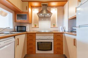 a kitchen with a stove and a microwave at Sunny Golden 1BDR Apartment w Beach & Pool Access Included in Cabanas de Tavira