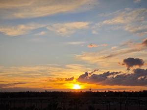 a sunset with the sun setting in the sky at Riad Sijane in Marrakech